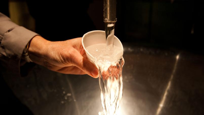 Image: A visitor filling up a cup of spa water