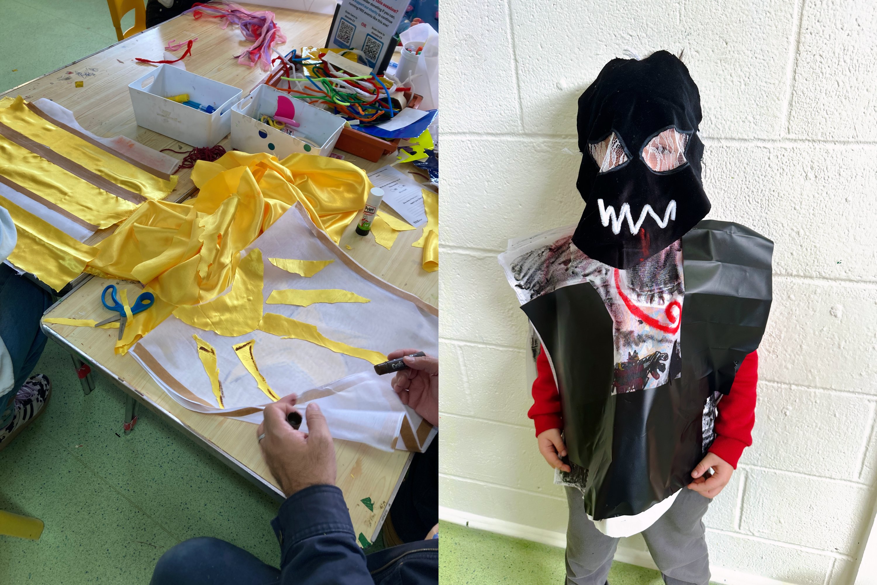 Child wearing a handmade black, red and white costume beside a table covered with fabric, craft materials and scissors during a creative workshop.