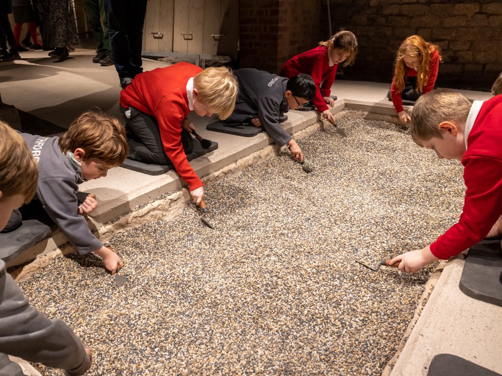 Image: Schoolchildren digging for replica archaeological objects in the investigation zone