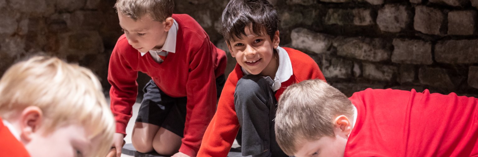 Image: Children digging for replica archaeological objects in an investigation zone