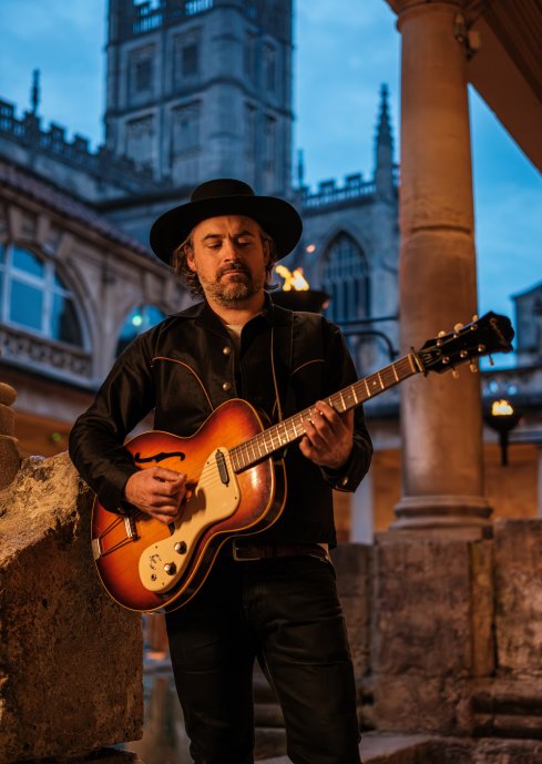 torchlit musician by the great bath