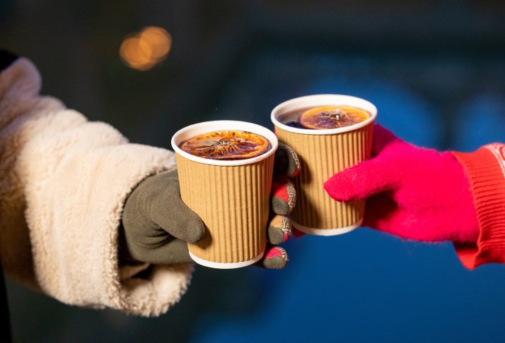 Image: Two hands holding cups of mulled wine